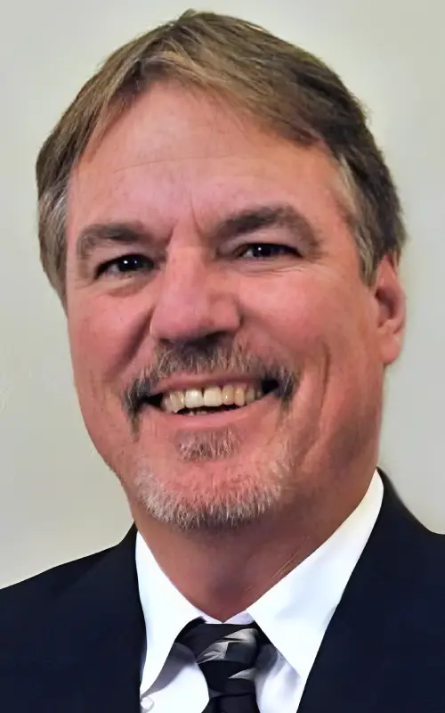 Man in a suit and tie at the camera against a white background